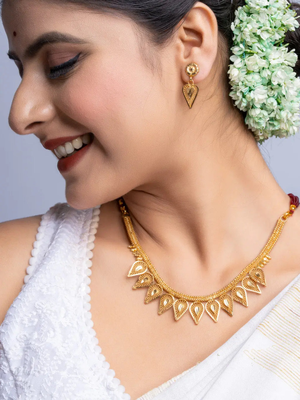 Gold Plated Necklace Set with intricate design worn by woman in traditional attire and floral hair accessory