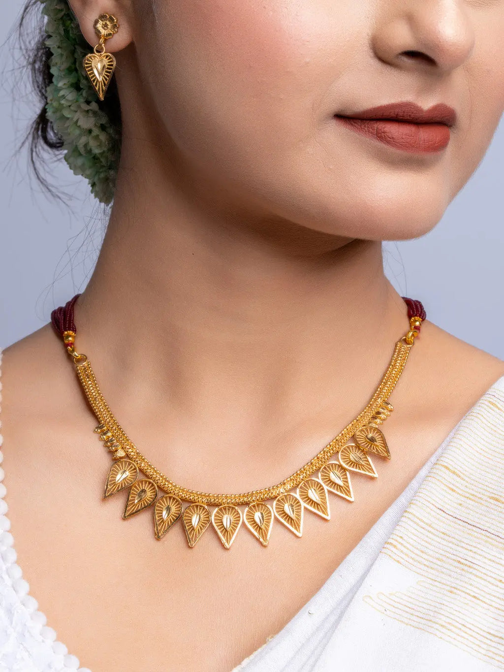 Gold Plated Necklace Set with intricate leaf-shaped pendants worn by woman in traditional attire