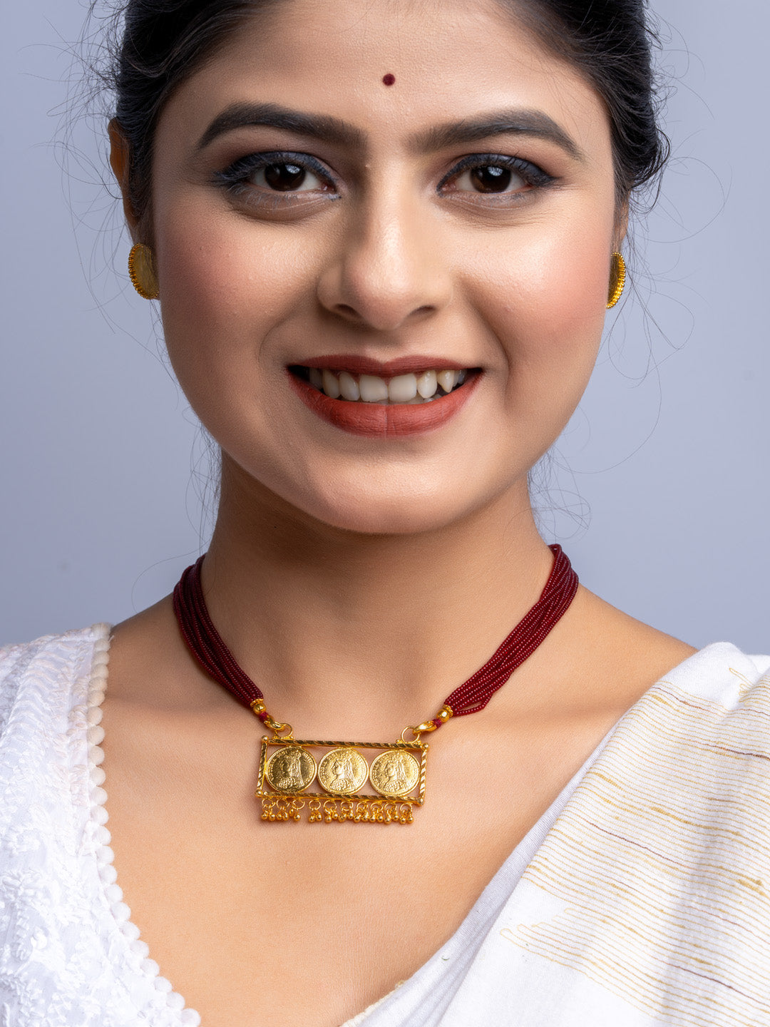 Woman wearing LOOK AND ADORN gold plated necklace set with maroon thread and intricate pendant design