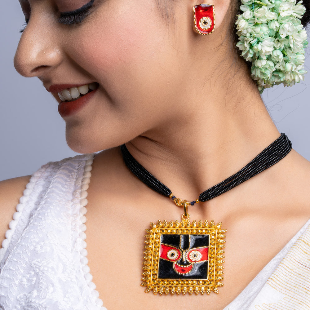 Gold plated necklace set with traditional pendant worn by woman in white saree and floral hair accessory