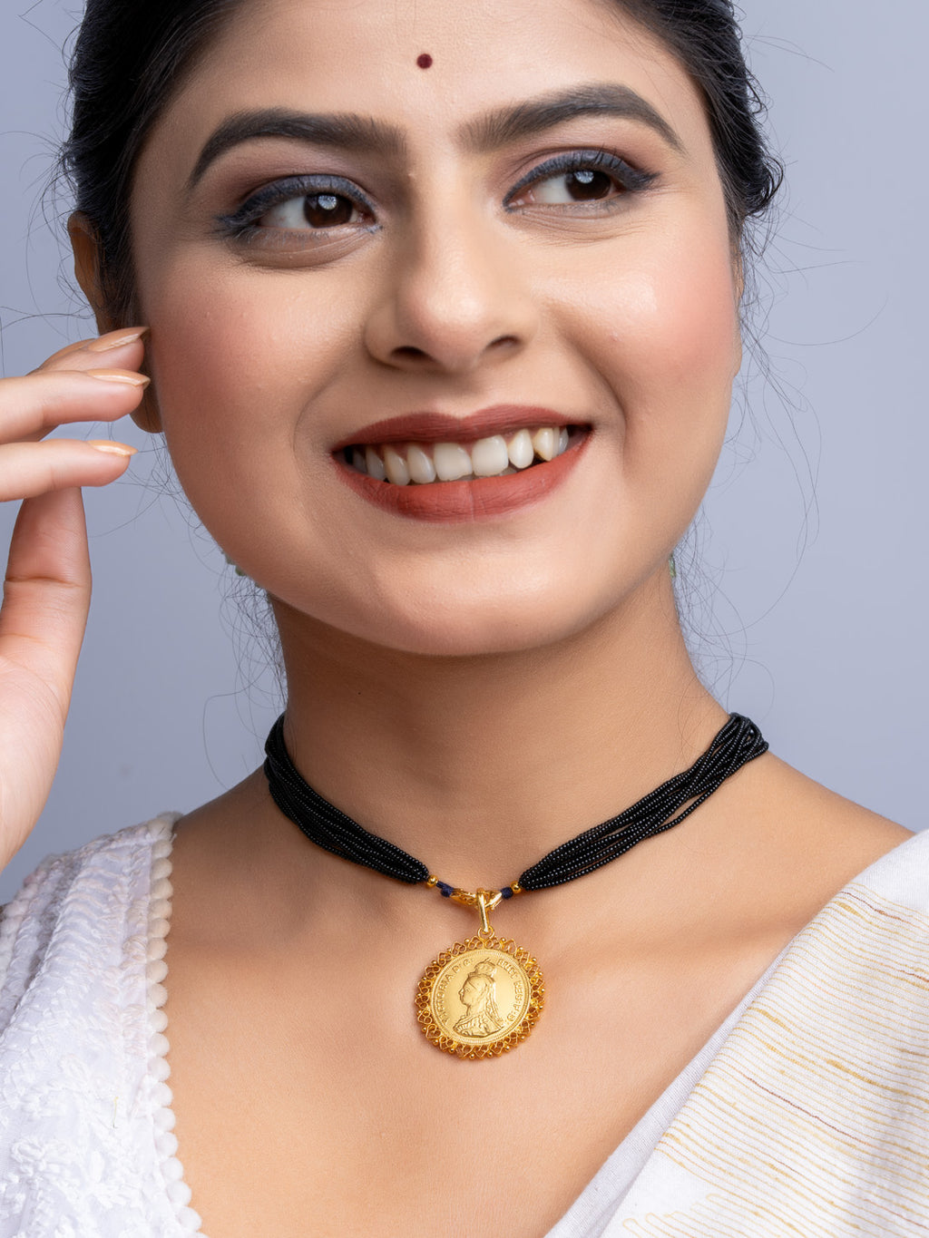Woman wearing gold plated pendant with black multi-strand necklace from LOOK AND ADORN