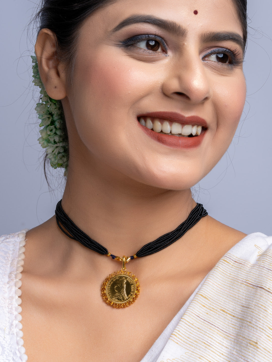 Smiling woman wearing black beaded necklace with gold plated pendant from LOOK AND ADORN