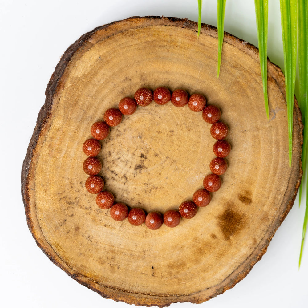 Gold sandstone bracelet by LOOK AND ADORN featuring smooth, polished gemstones on a wooden display