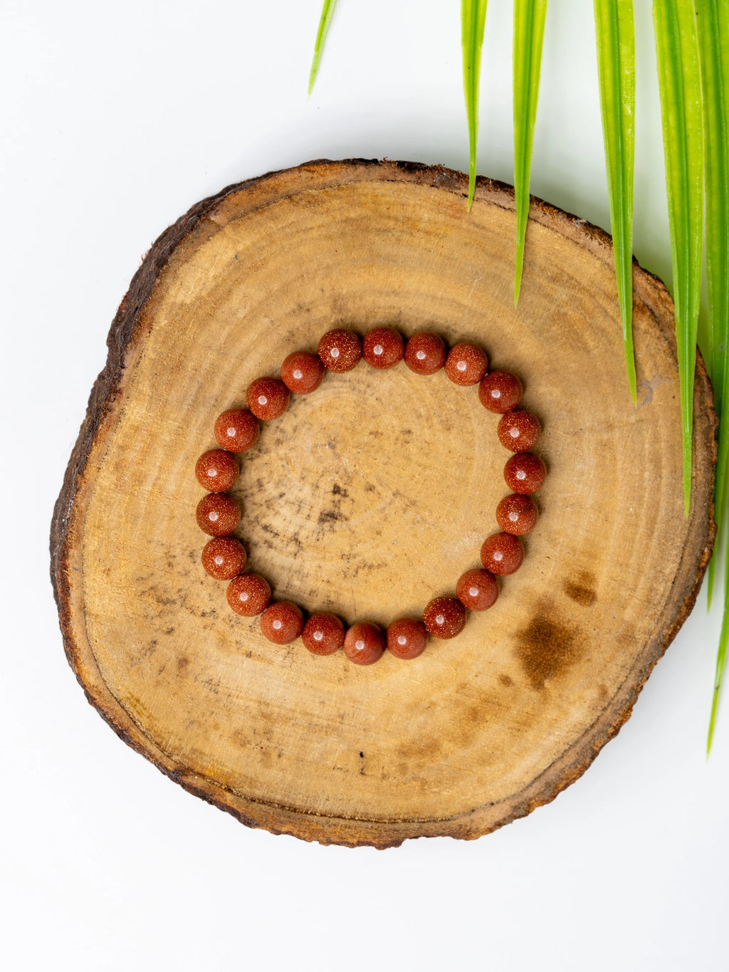 Gold sandstone bracelet by LOOK AND ADORN featuring smooth, polished gemstones on a wooden display