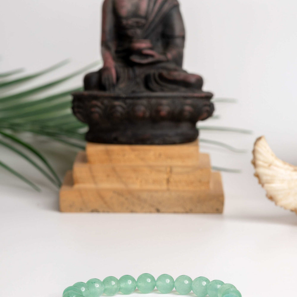 Green aventurine bracelet featured in front of a Buddha statue, ideal for spiritual practices