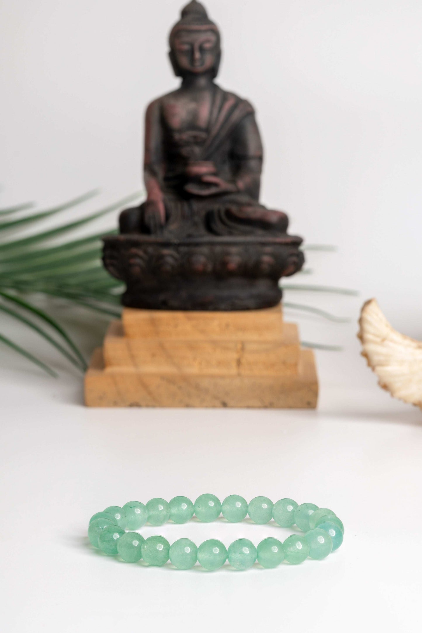 Green aventurine bracelet featured in front of a Buddha statue, ideal for spiritual practices