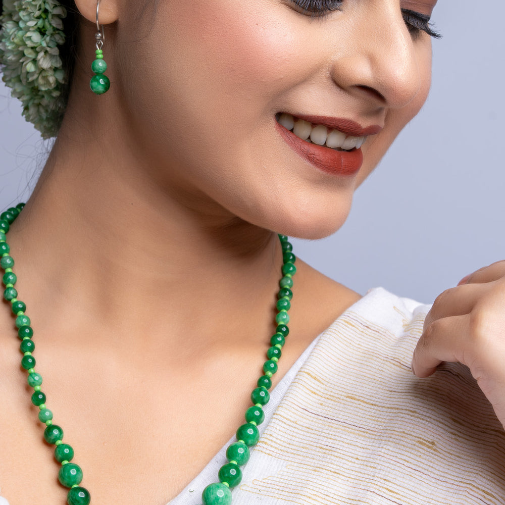 Handmade green onyx necklace with matching earrings worn by woman in traditional white attire