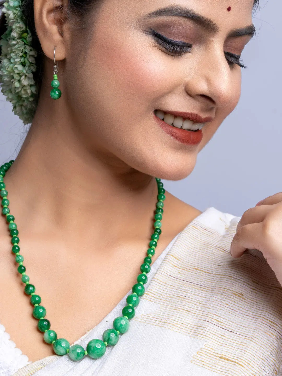 Handmade green onyx necklace with matching earrings worn by woman in traditional white attire