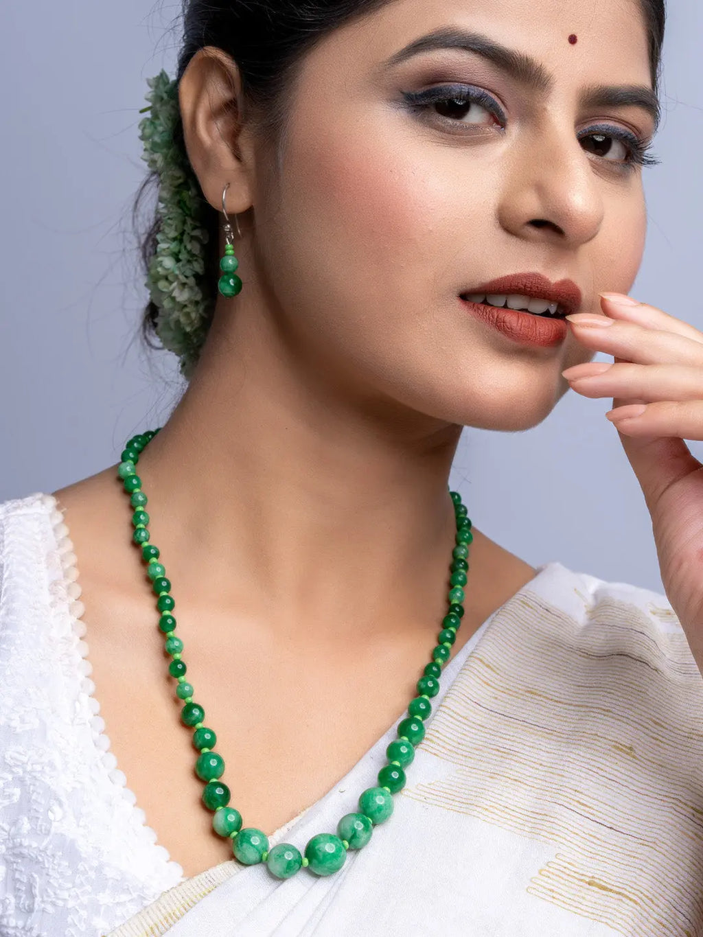 LOOK AND ADORN handmade green onyx necklace worn by woman with matching earrings in white traditional attire