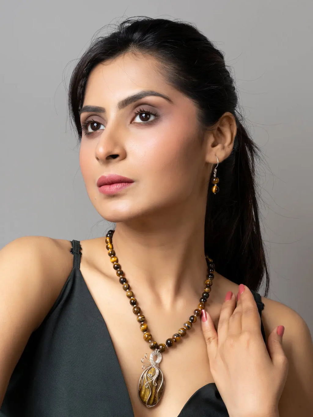 Woman wearing a handmade tiger eye necklace with matching earrings from LOOK AND ADORN