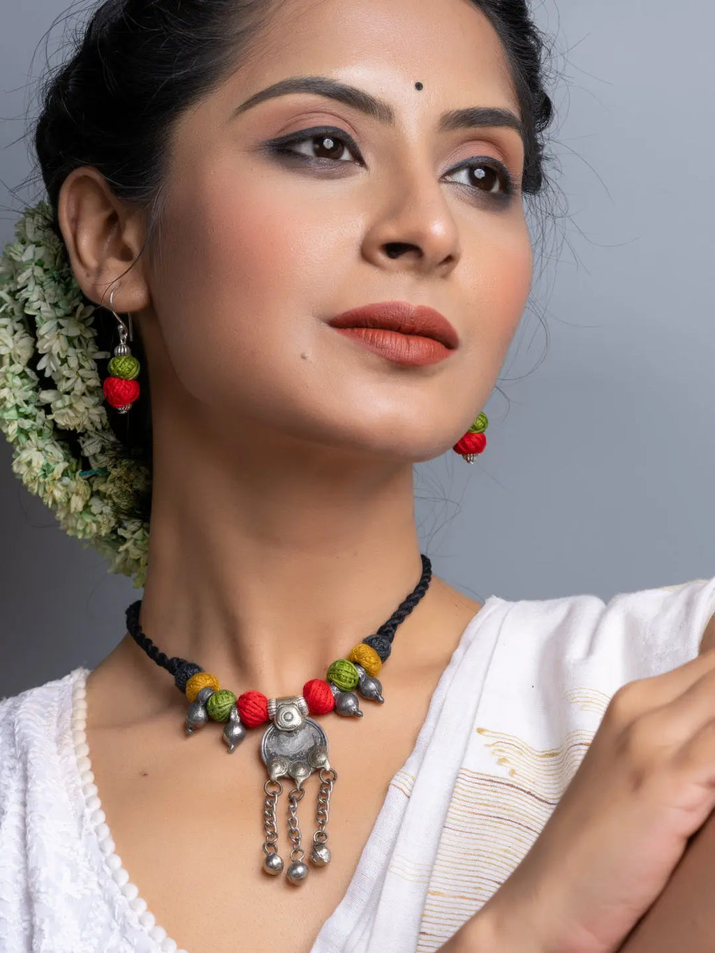 Woman wearing colorful Afghani necklace set with traditional beads and metal pendant from LOOK AND ADORN