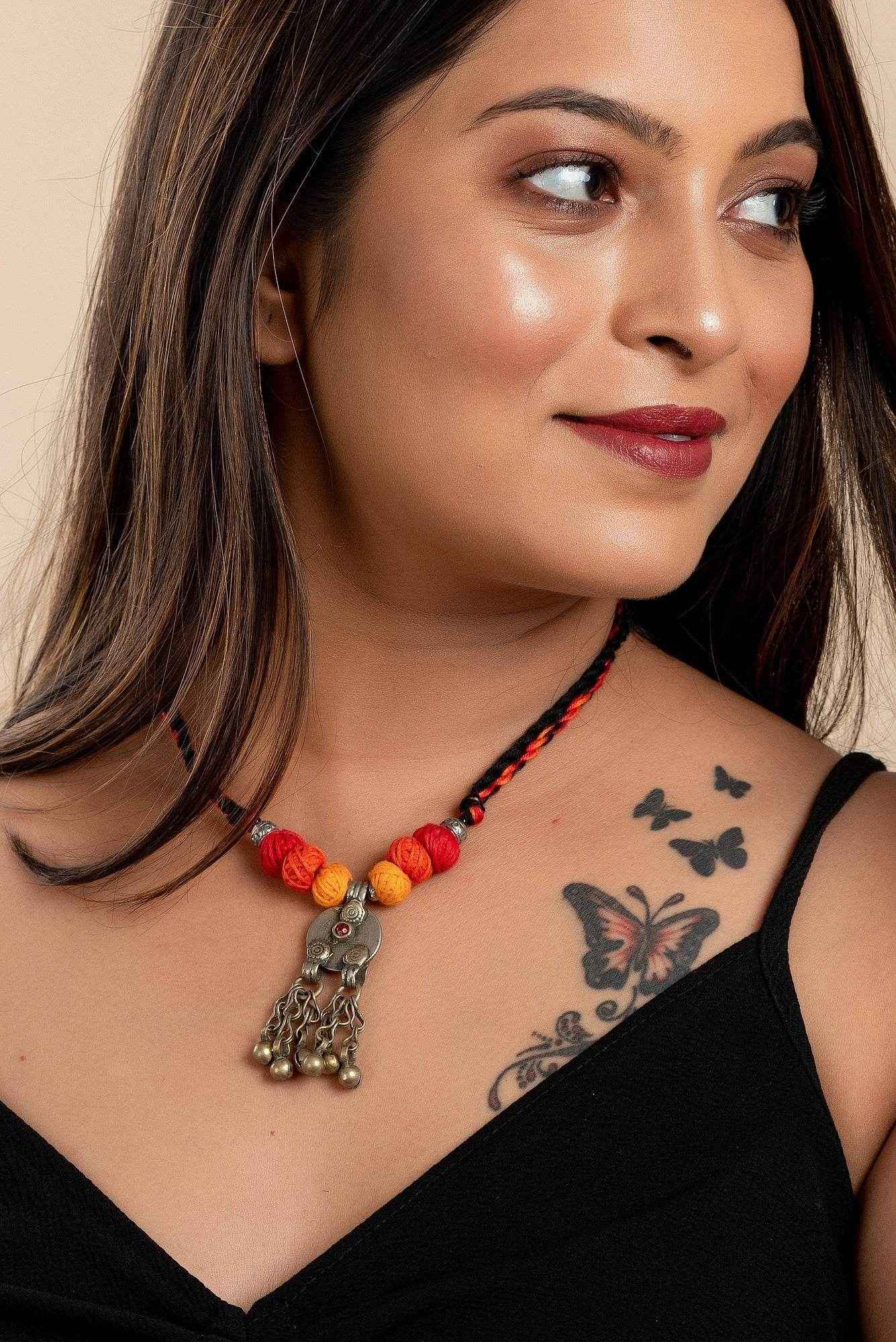 Afghan Tibetan brass oxidised silver necklace with colorful beads worn by woman showcasing handmade jewelry
