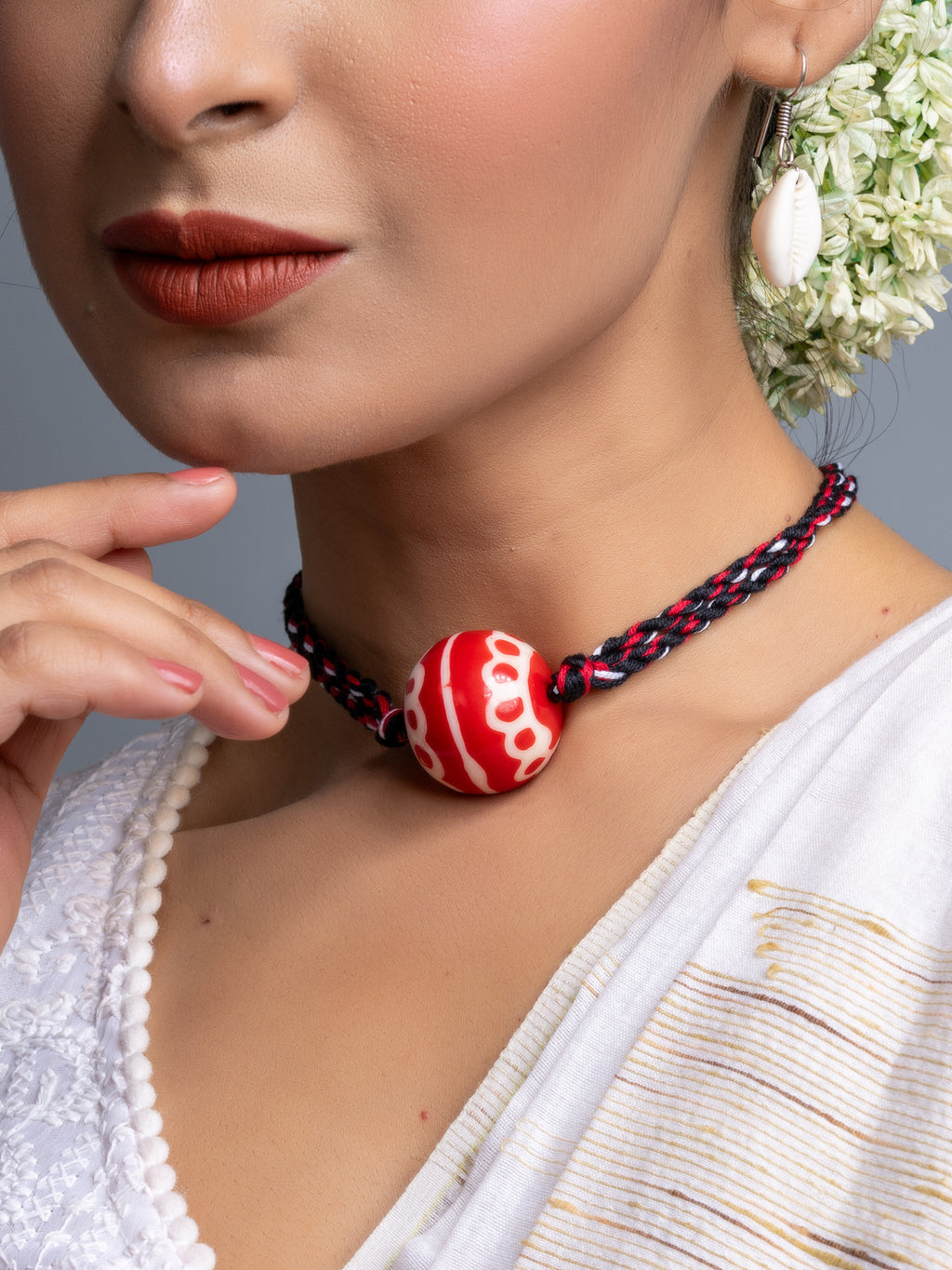 Handmade necklace set featuring a red and white beaded pendant on a braided black and red cord by LOOK AND ADORN