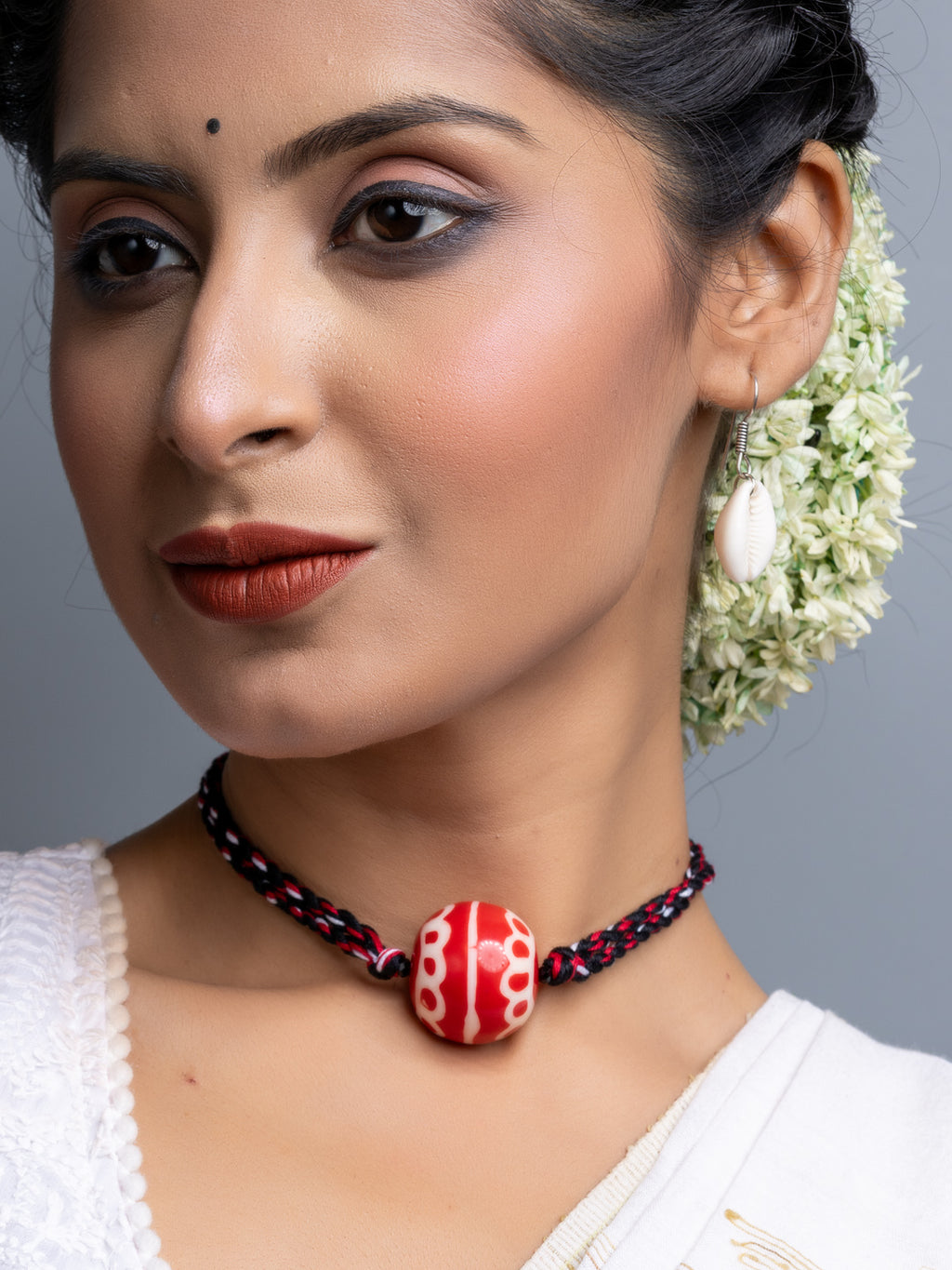 Handmade necklace set with a red and white bead on a black and red braided cord by LOOK AND ADORN