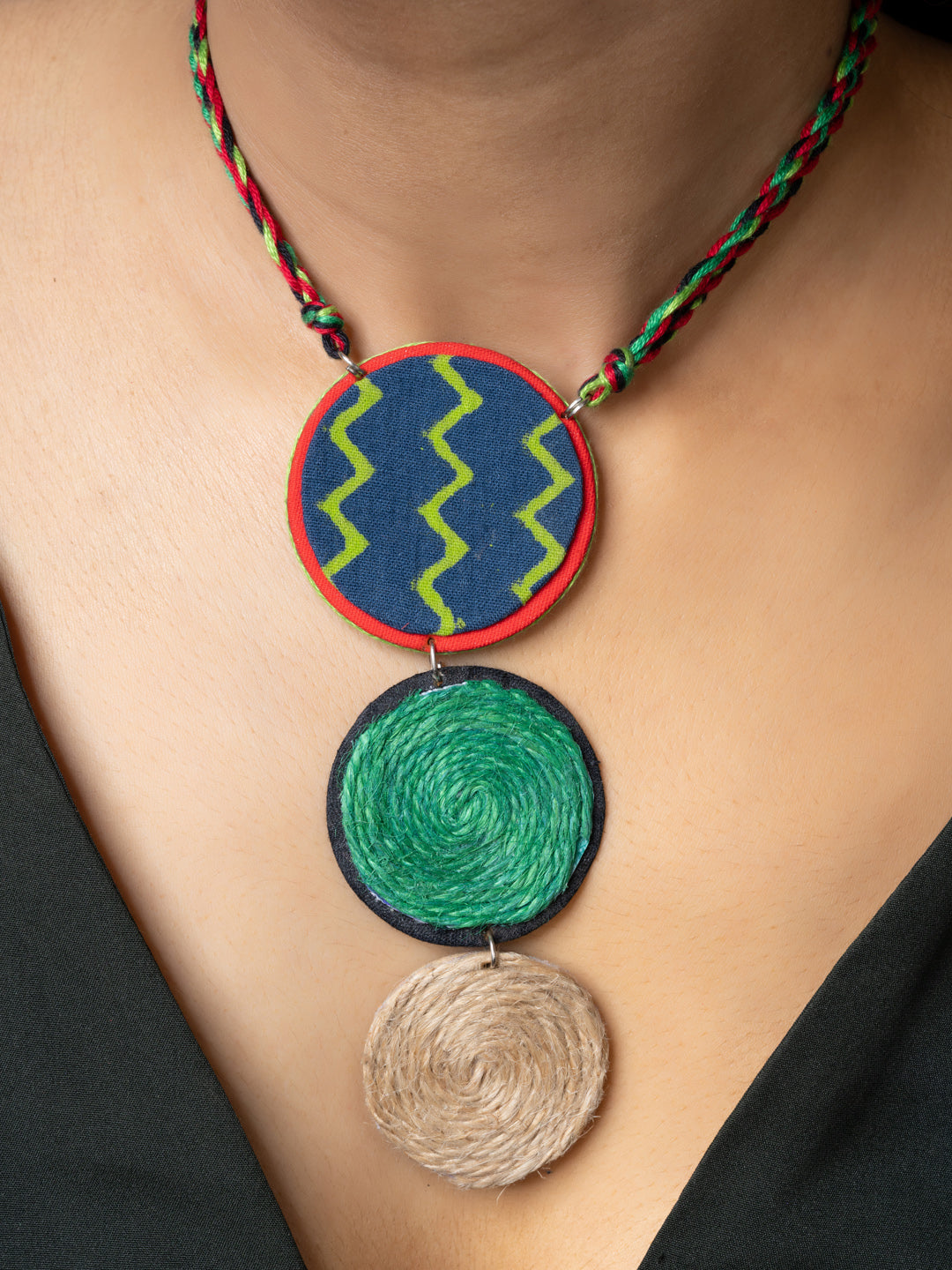 Handmade jute necklace with colorful circular pendants and braided red and green cord