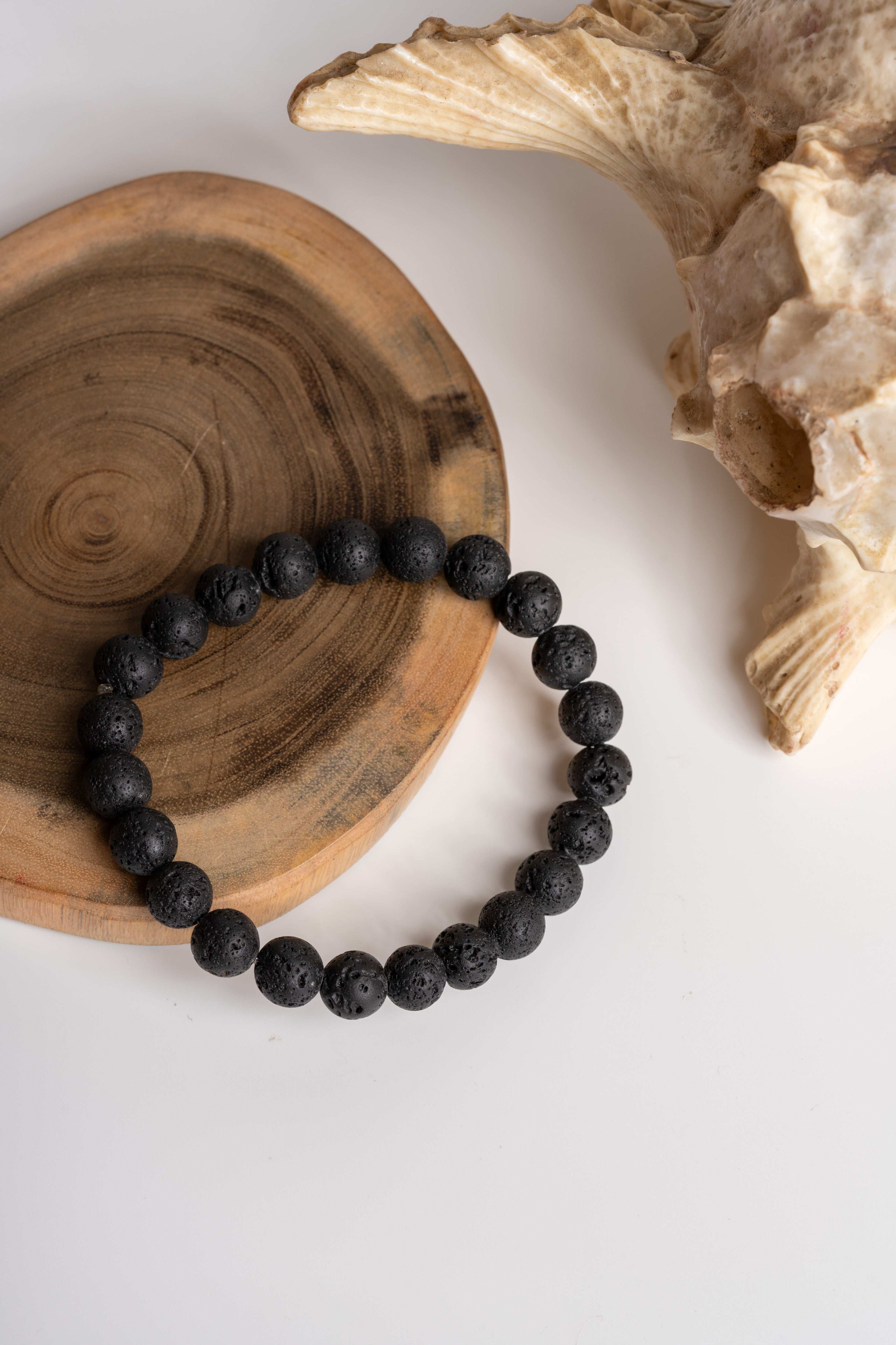 Lava stone bracelet by LOOK AND ADORN featuring natural black lava beads on a wooden display