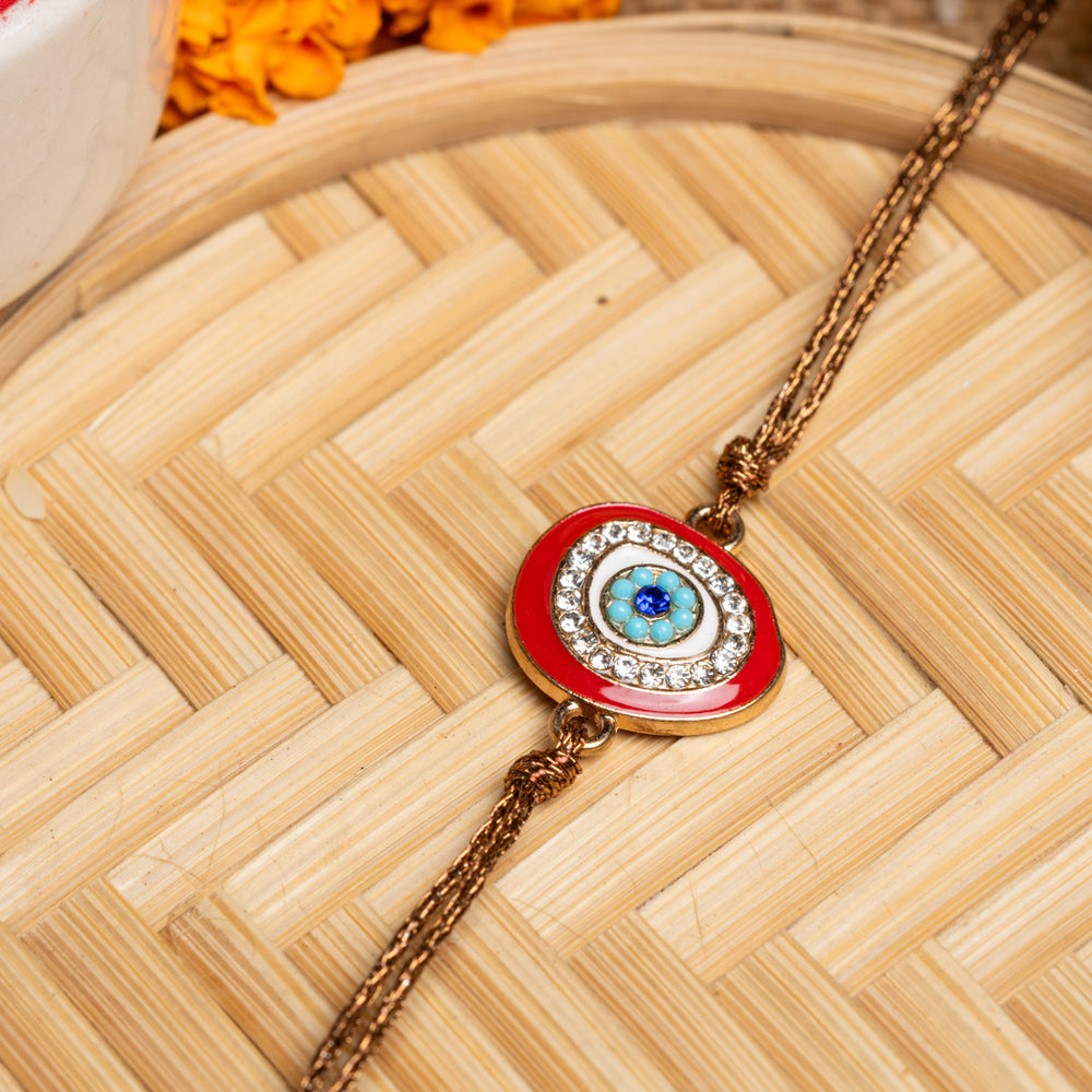 LOOK AND ADORN evil eye rakhi with blue eye centerpiece and decorative crystals on golden thread