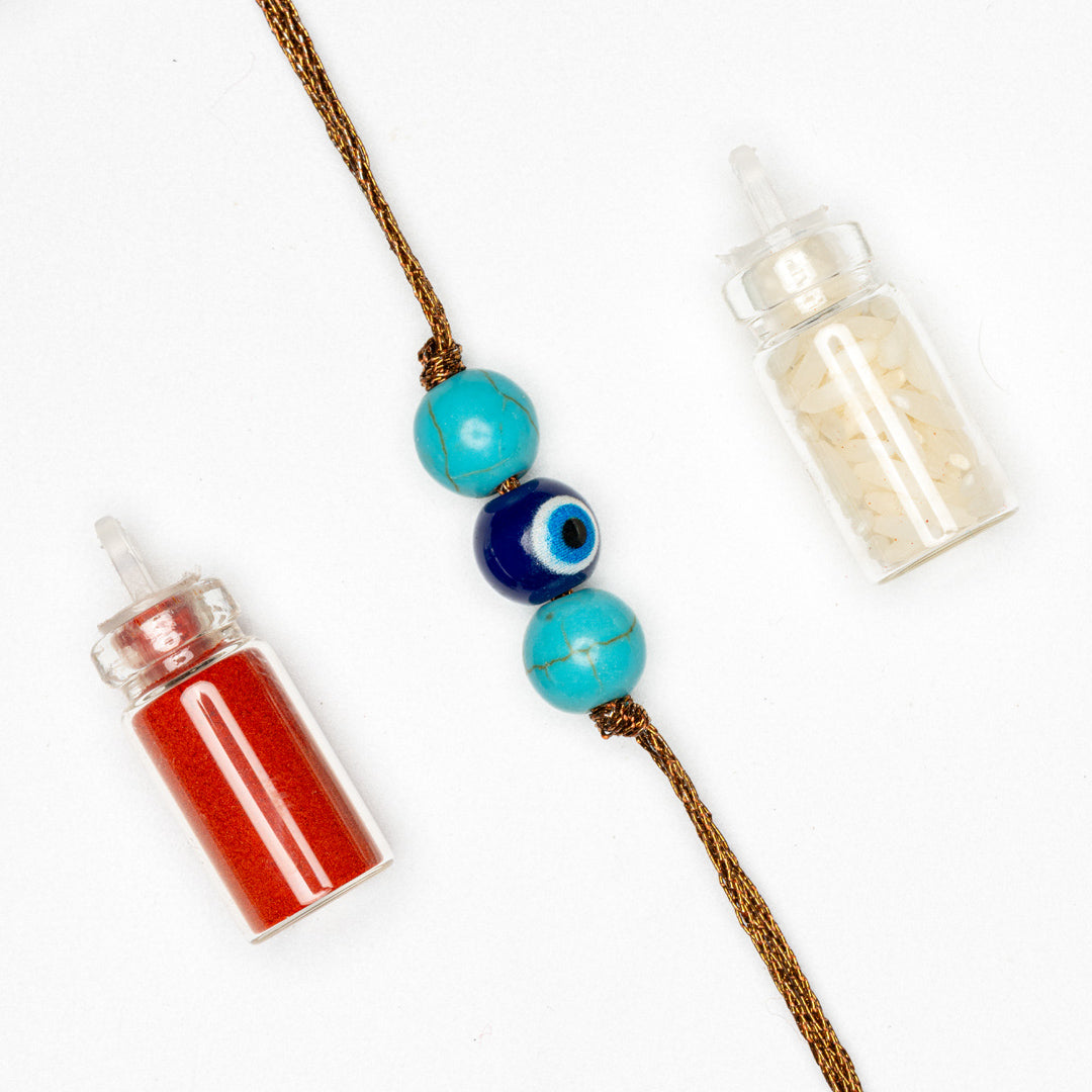 LOOK AND ADORN evil eye rakhi with turquoise beads and protective charm with red and white powders