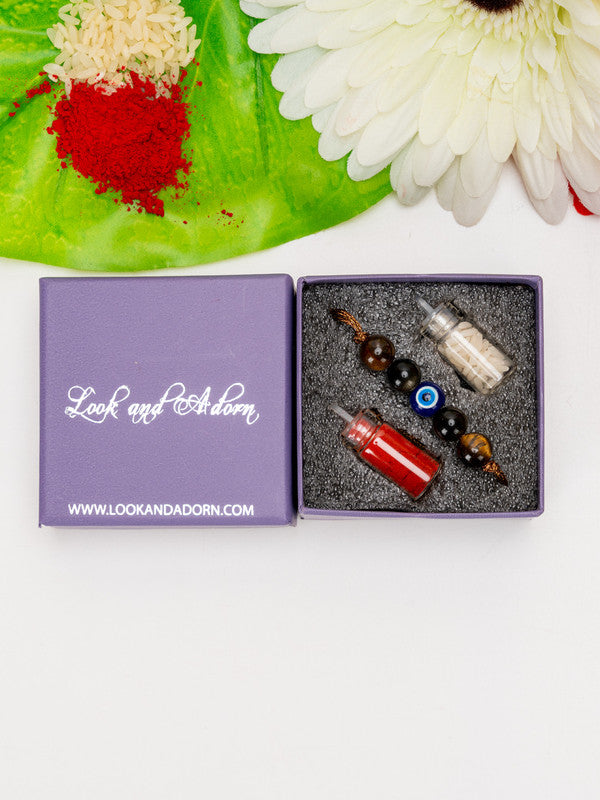 LOOK AND ADORN evil eye rakhi in a purple box with red and white thread containers for traditional celebration