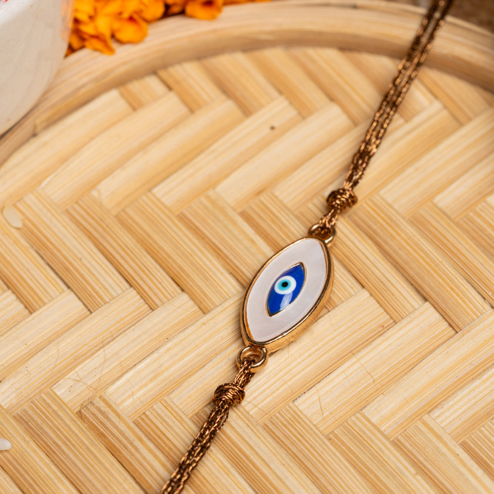 LOOK AND ADORN evil eye rakhi with blue and white charm on a brown braided thread