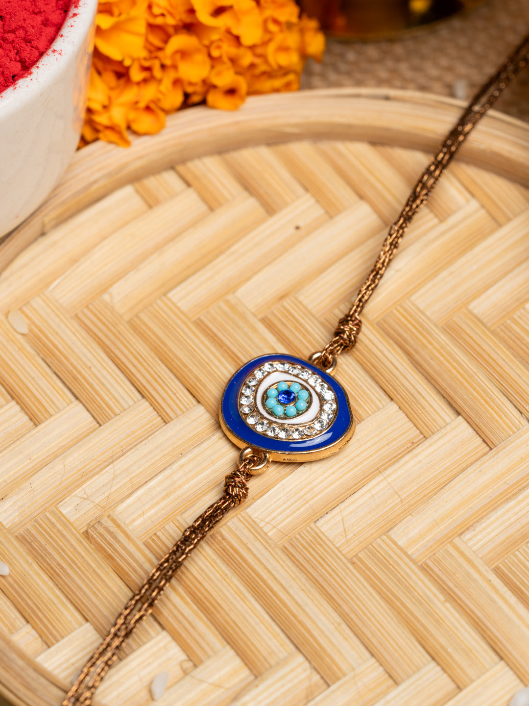 LOOK AND ADORN evil eye rakhi with blue and white stones on a golden chain for protection