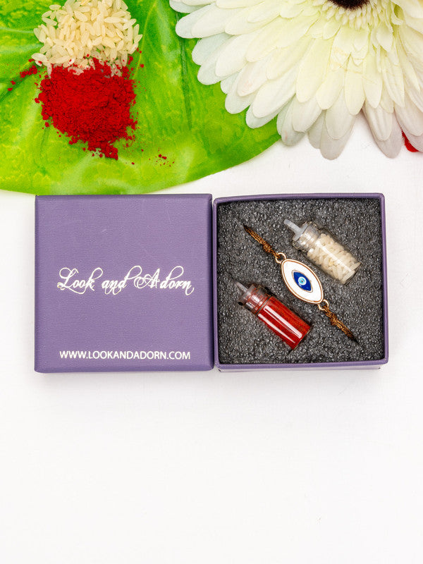 LOOK AND ADORN evil eye rakhi with red and white powder in decorative purple box on white background