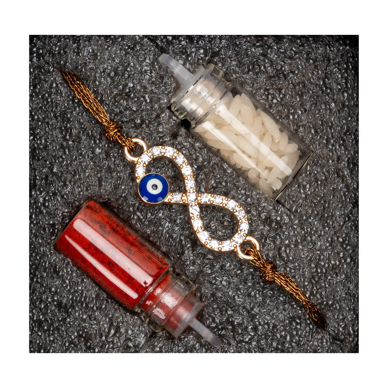 LOOK AND ADORN evil eye rakhi with infinity symbol and sparkling stones next to red and white decorative tubes