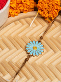LOOK AND ADORN floral rakhi with blue petals and yellow center on a woven bamboo background