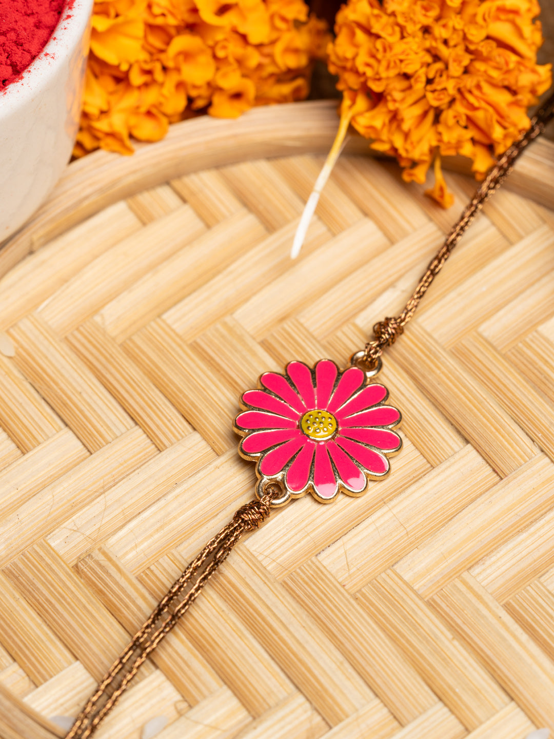 LOOK AND ADORN floral rakhi with pink flower design and golden chain on wooden background
