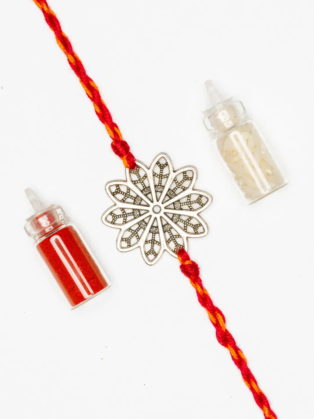 LOOK AND ADORN floral rakhi with red and yellow thread and decorative flower design with color powders