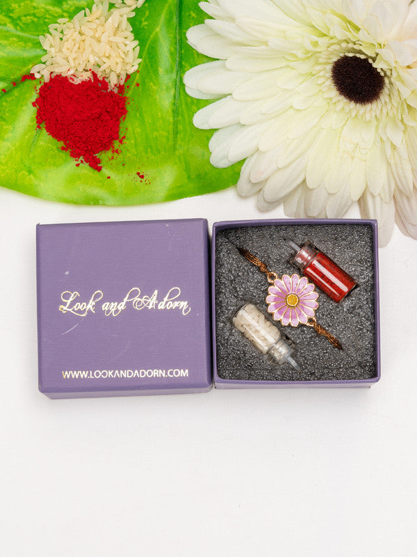 LOOK AND ADORN floral rakhi in a purple gift box with traditional red and white powders and a white flower