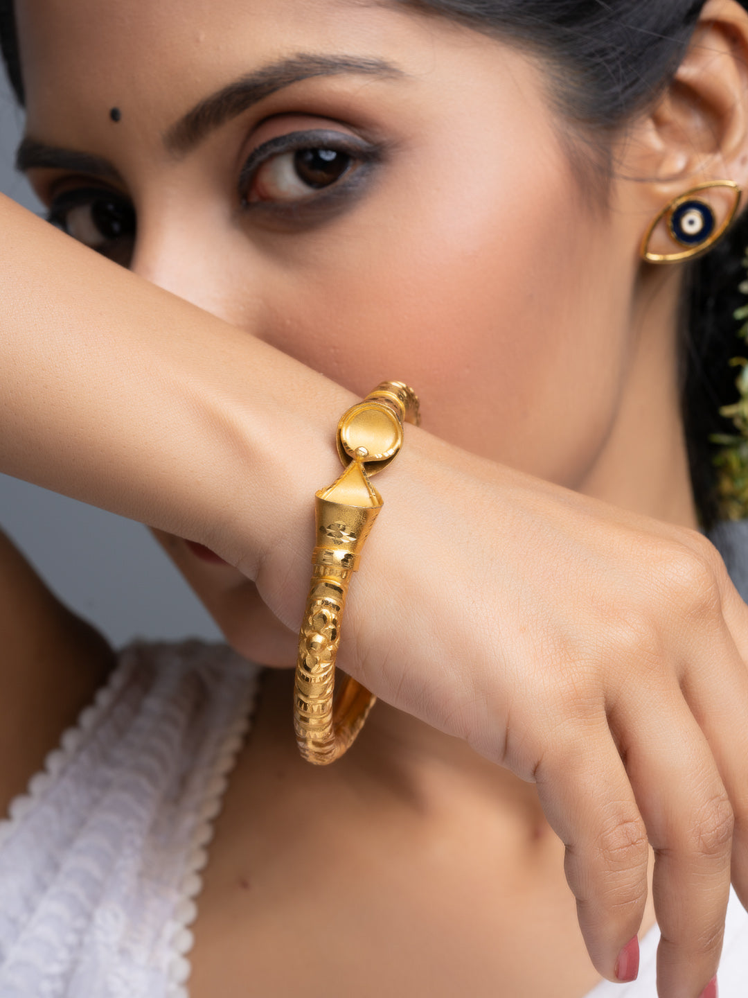 LOOK AND ADORN gold plated bangle worn on model wrist ornate textured traditional design