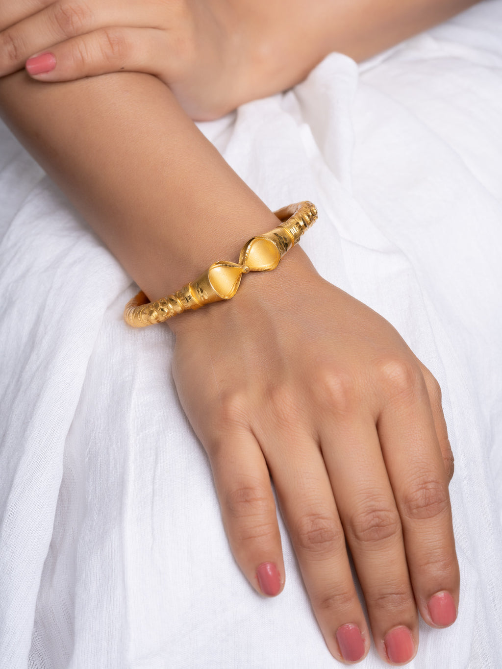 LOOK AND ADORN gold plated bangle with twin teardrop motifs and textured rope band on wrist