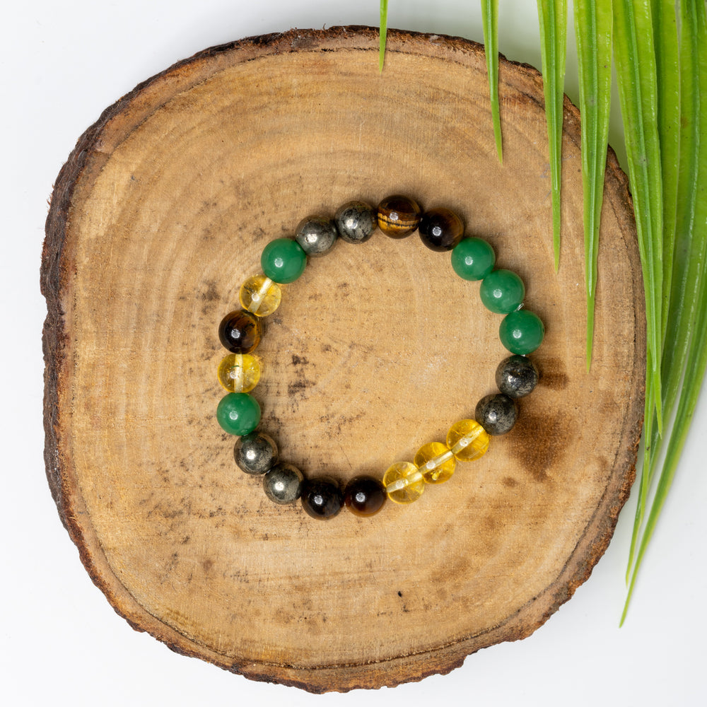 Astro-Gemstone Jewellery money magnet bracelet with green, yellow, and black stones on a wooden display