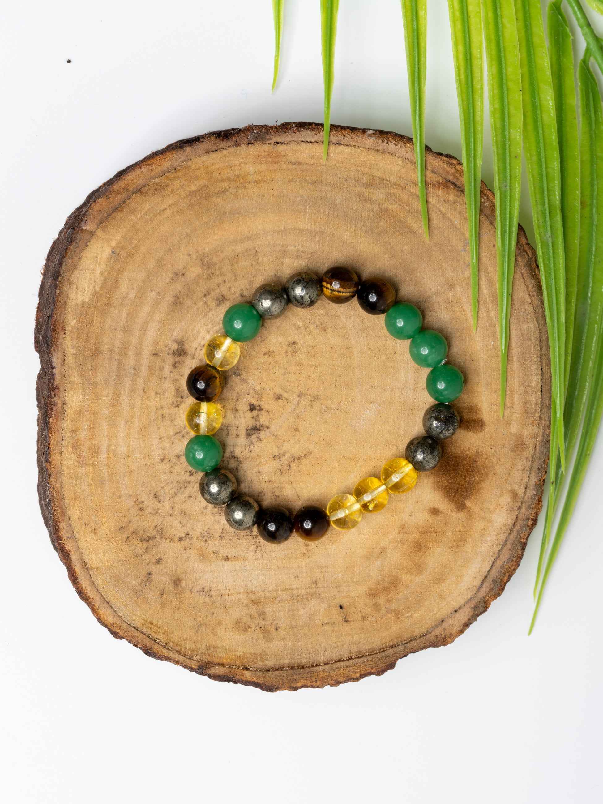 Astro-Gemstone Jewellery money magnet bracelet with green, yellow, and black stones on a wooden display