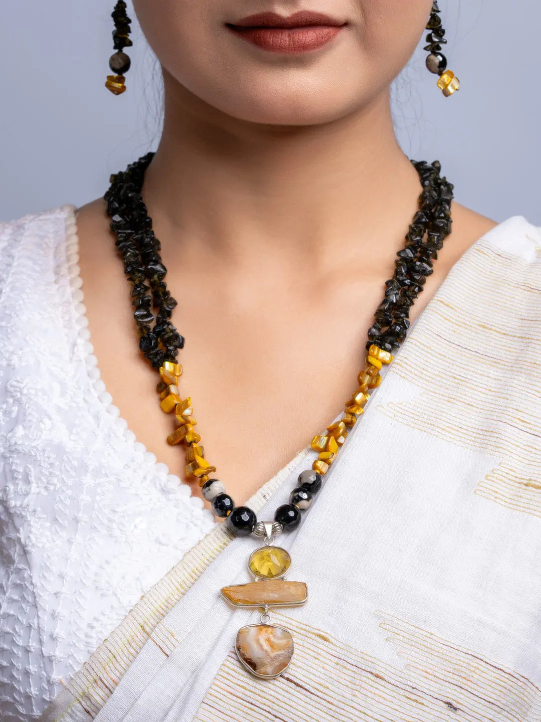 Handmade Mother of Pearl Necklace Set with black and amber beads worn with white traditional attire