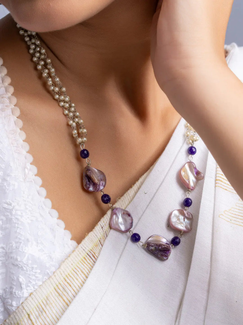 Handmade mother of pearl necklace set with purple beads worn with white traditional attire
