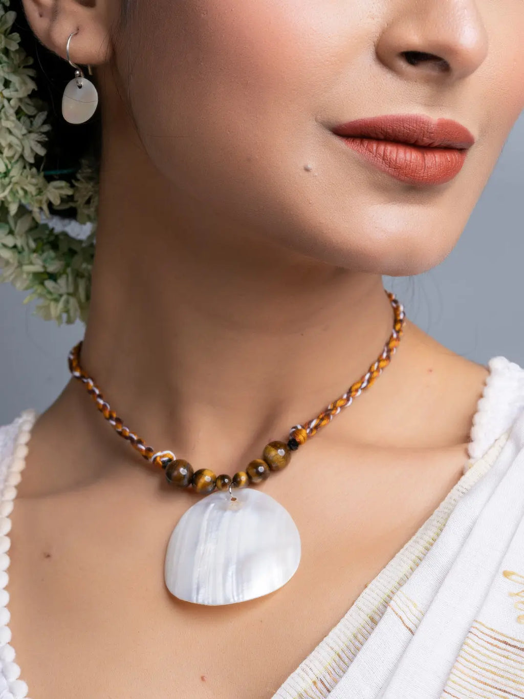 Handmade mother of pearl necklace set with beads worn by woman, showcasing elegant design
