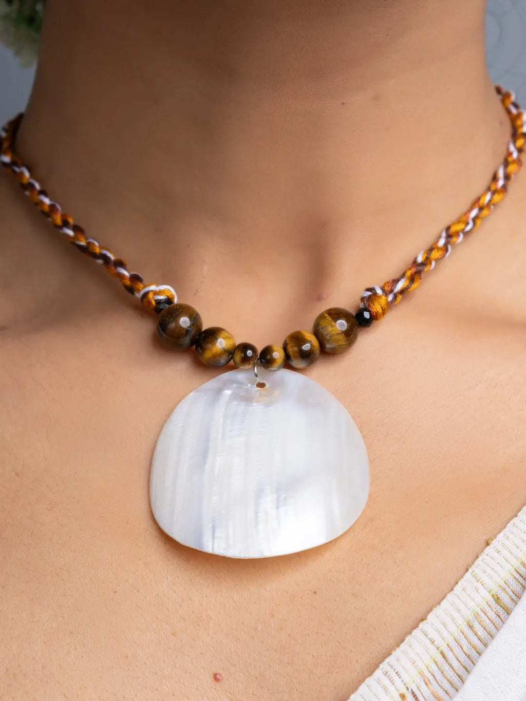 Handmade mother of pearl necklace set with a large white shell pendant and brown braided cord