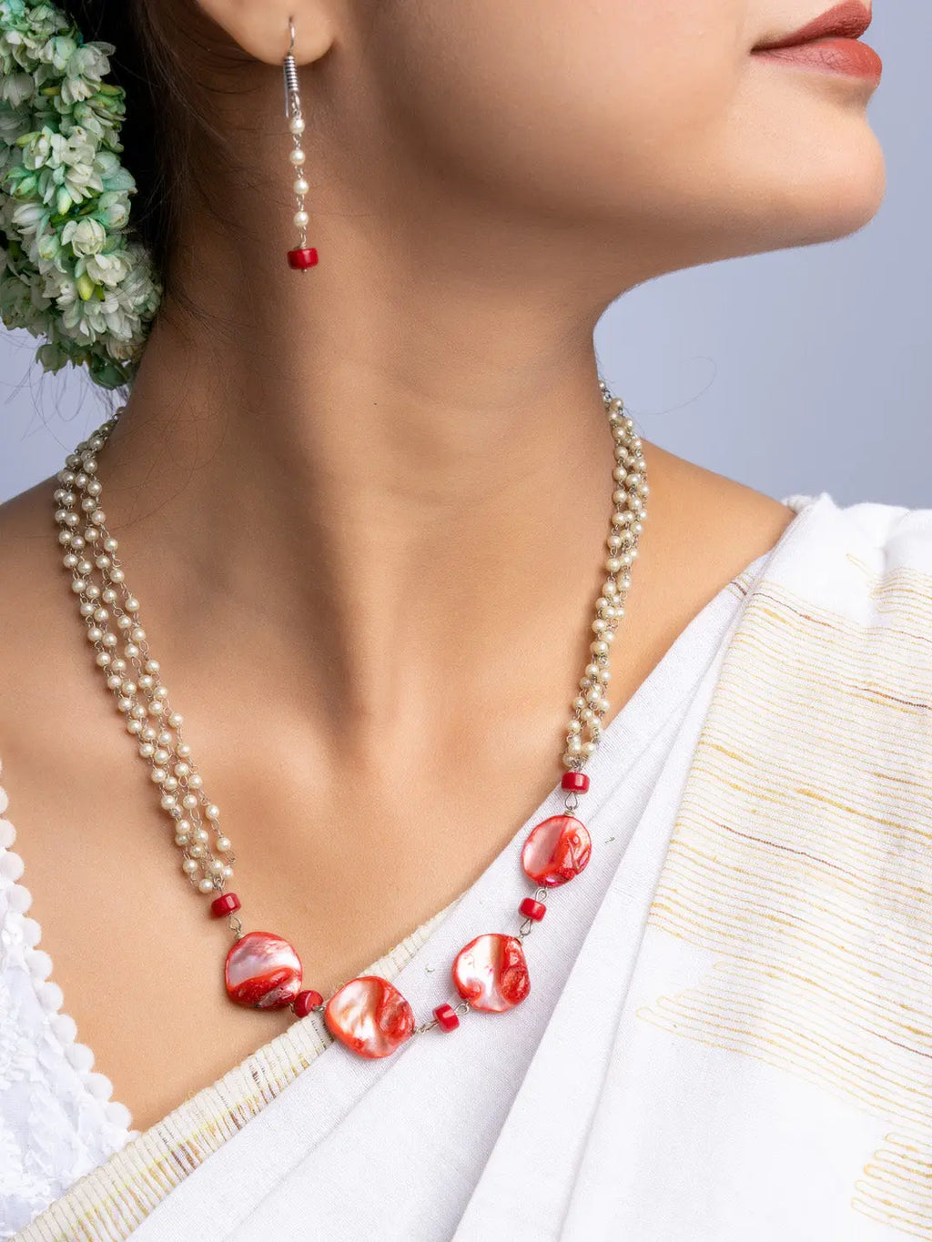 Handmade mother of pearl necklace set with red and white beads worn with matching earrings