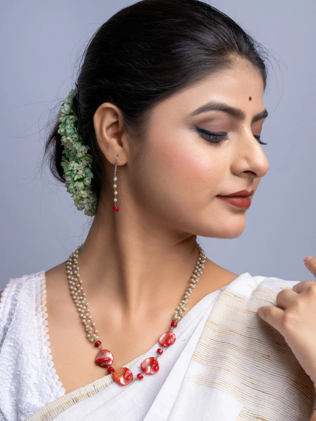 Woman wearing handmade mother of pearl necklace set with red and pearl beads from LOOK AND ADORN
