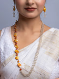 Woman wearing a handmade mother of pearl necklace set with orange and white beads and matching earrings