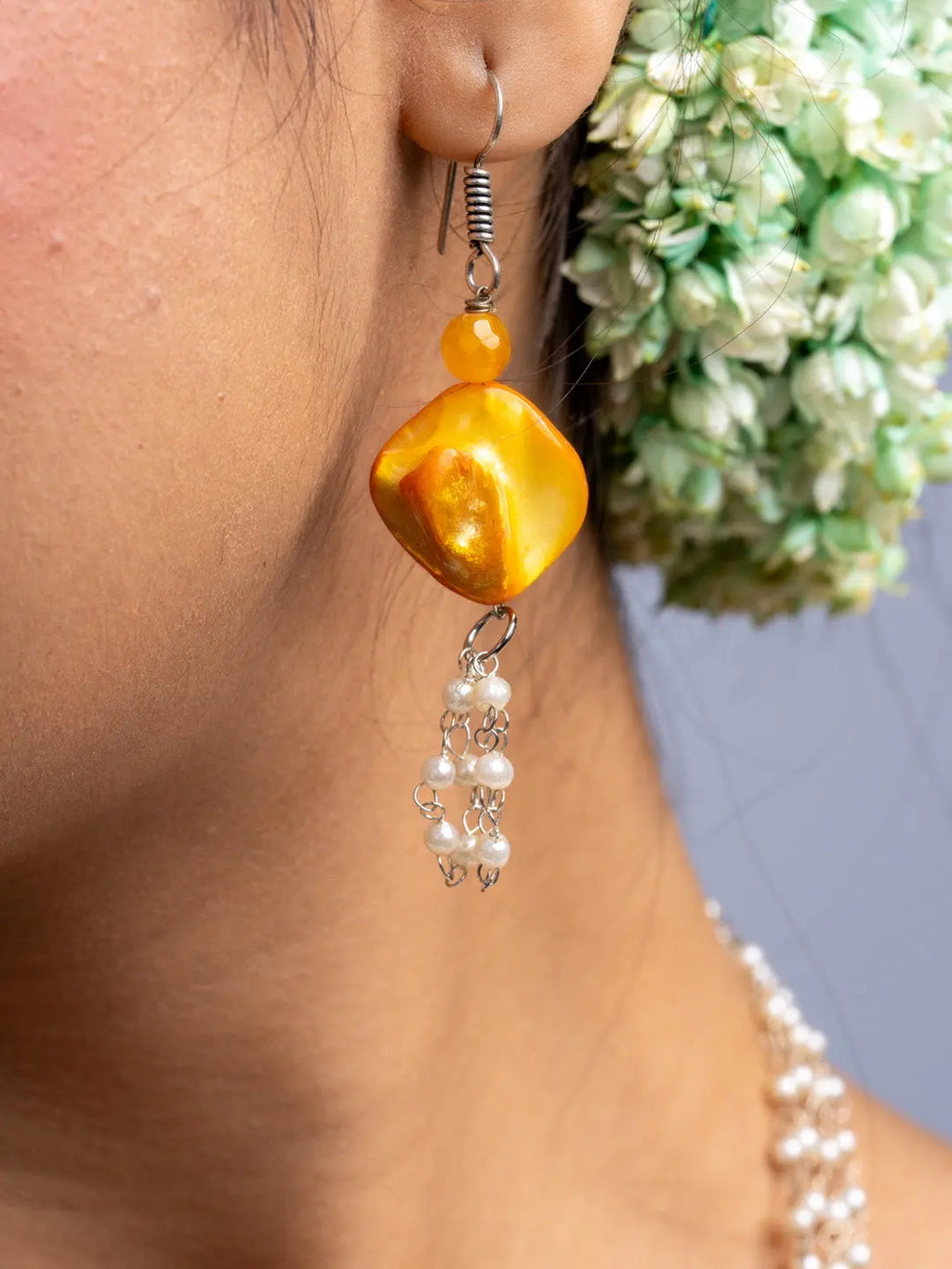Close-up of handmade mother of pearl necklace set featuring yellow pendant and pearl earrings by LOOK AND ADORN