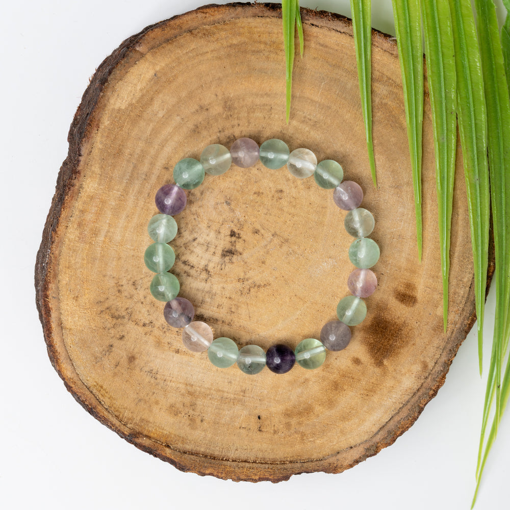 Multi fluorite bracelet beautifully crafted with assorted colored gemstones on a wooden display