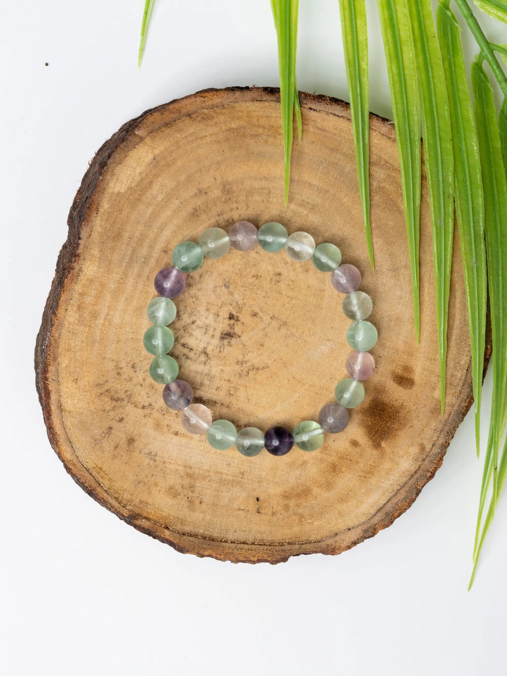 Multi fluorite bracelet beautifully crafted with assorted colored gemstones on a wooden display