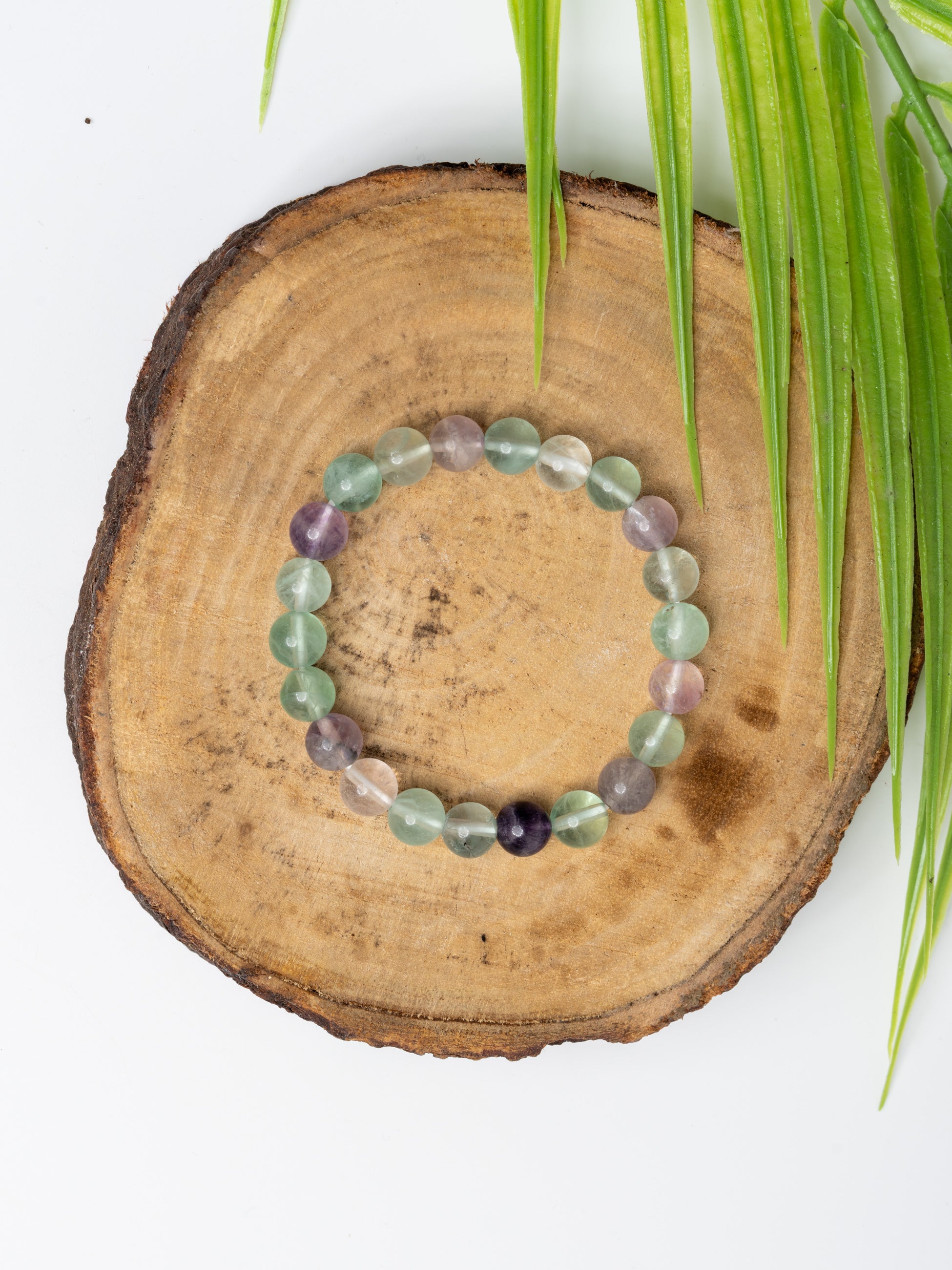 Multi fluorite bracelet beautifully crafted with assorted colored gemstones on a wooden display