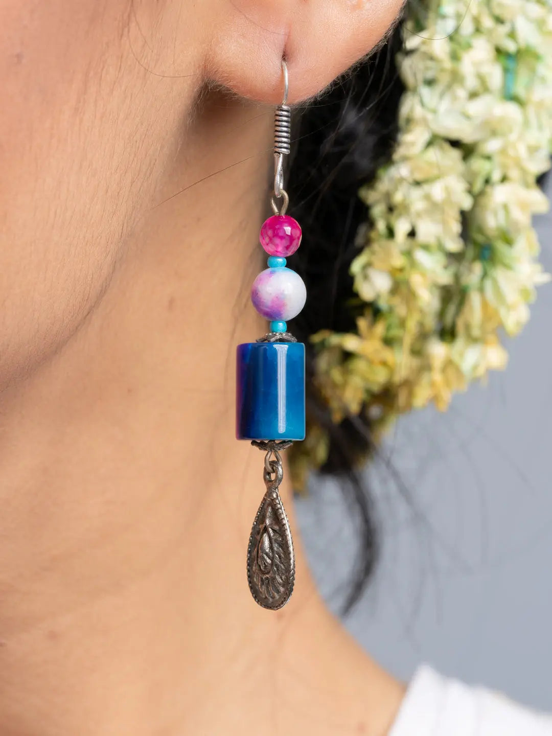 Handmade onyx earrings with colorful beads and silver drop detail worn on ear