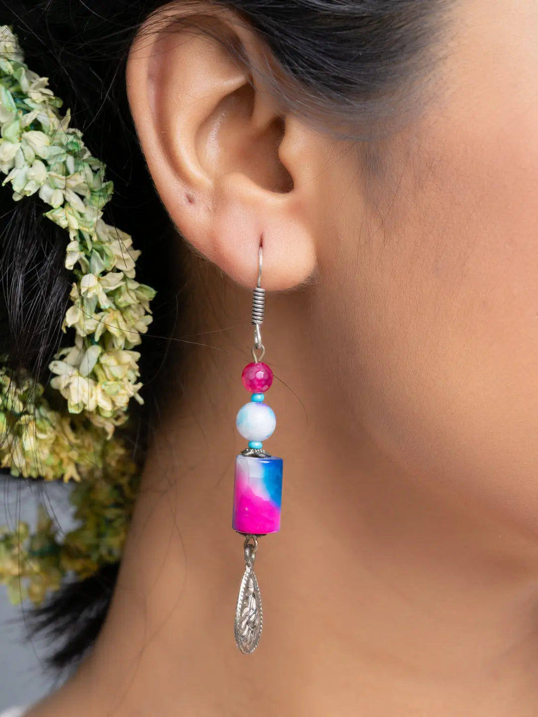 Handmade onyx earrings with colorful beads and silver dangle detail worn on ear