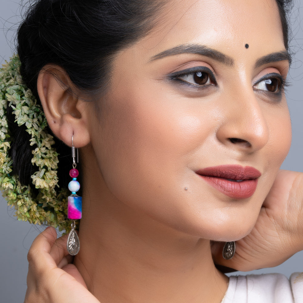 Handmade onyx earrings worn by woman with intricate design and colorful beads