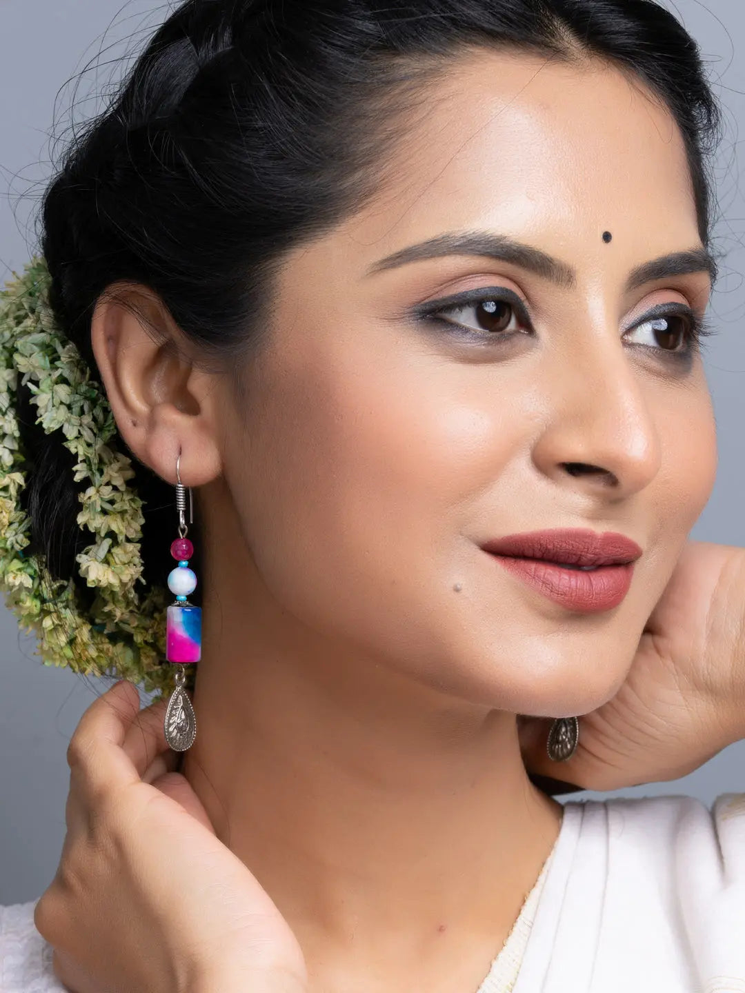 Handmade onyx earrings worn by woman with intricate design and colorful beads